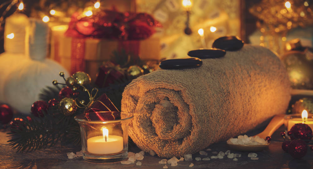 A warm setting of candles, a towel, healing salts and rocks.